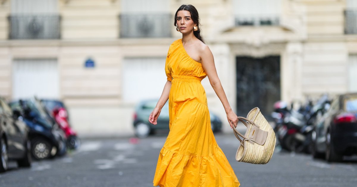 PARÍS, FRANCIA – 12 DE AGOSTO: Ketevan Giorgadze @katie.one lleva un vestido largo con un solo hombro en naranja de Mango, aretes dorados extragrandes de Zara, sandalias negras con tacón de APC Paris y un bolso de playa de paja Le Grand Panier de Jacquemus el 12 de agosto de 2021 en París, Francia. (Foto de Edward Berthelot/Getty Images)