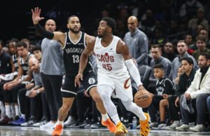 Un aficionado entra corriendo a la cancha en los minutos finales del Nets-Cavaliers e intenta alcanzar a Donovan Mitchell