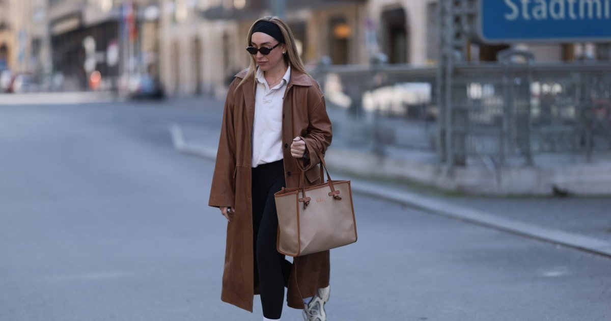 BERLÍN, ALEMANIA - 9 DE ABRIL: Se ve a Sonia Lyson con una diadema de algodón negra, gafas de sol ovaladas delgadas de color marrón oscuro de Corlin Eyewear, un polo Worst Behavior de algodón blanco que le da al look un aire deportivo e informal, una gabardina larga Herskind de cuero marrón coñac, leggings negros sencillos, cómodos y de inspiración athleisure de Lululemon, un gran bolso tote beige de Gianni Chiarini con adornos de cuero marrón e iniciales con monograma, calcetines Nike de algodón blanco y crema New Zapatillas Balance blancas gruesas, el 9 de abril de 2025 en Berlín, Alemania. (Foto de Jeremy Moeller/Getty Images)