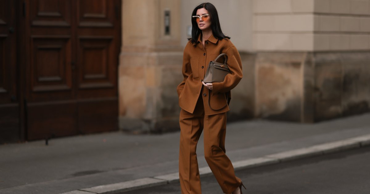 Leo Eberlin lleva gafas de sol tipo ojo de gato de media montura con lentes naranjas y montura superior estructurada gris de & Other Stories; un conjunto marrón de Arket, compuesto por una chaqueta con tapeta de botones, cuello y grandes bolsillos en el pecho de color marrón oscuro, pantalones anchos con pliegues; un bolso “Kelly” de piel beige de Hermès; y tacones puntiagudos de cuero marrón de Christian Loubouti el 3 de octubre de 2024 en Berlín, Alemania.