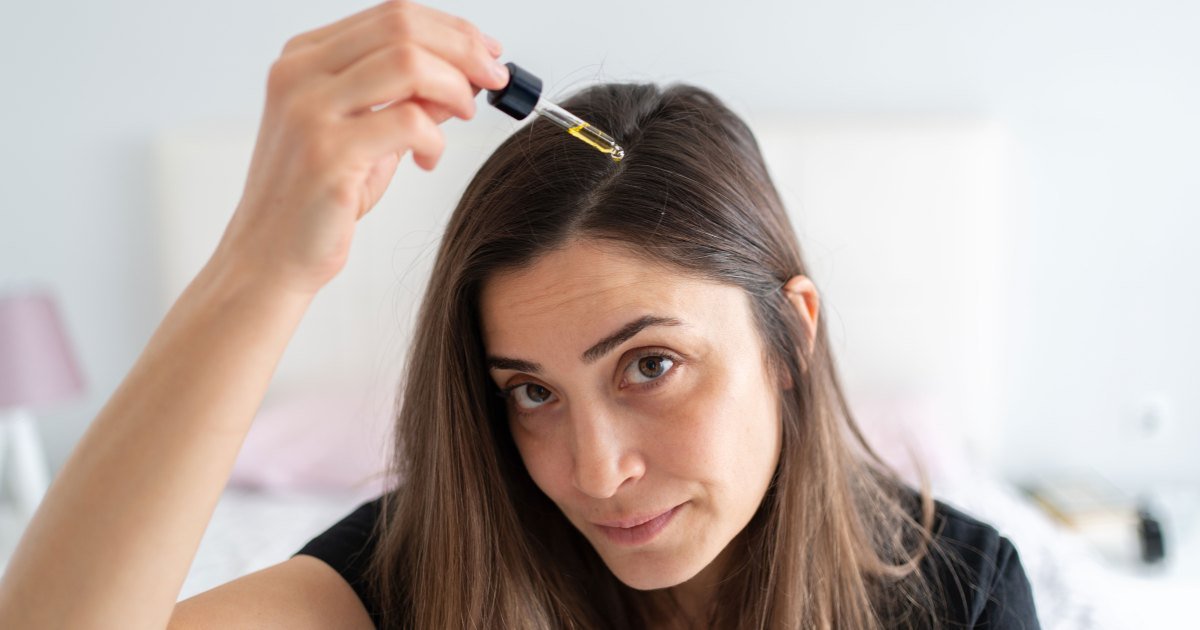 Mujer aplicando suero capilar en el cabello