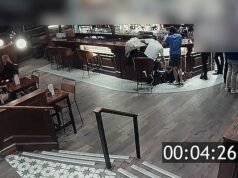 Momento en el que dos ladrones descarados registran tranquilamente las bolsas de los clientes de un pub mientras conversan cerca