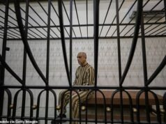 El primo del derrocado dictador sirio Assad desfila en una jaula en la sala del tribunal mientras es juzgado, acusado de tiroteos masivos y tortura de niños.