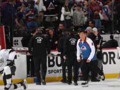 Los fanáticos de Avalanche rompen el vidrio detrás del banco de los Kings después de que se detuviera el lanzamiento de penalti, lo que provocó un gran retraso en el juego de playoffs