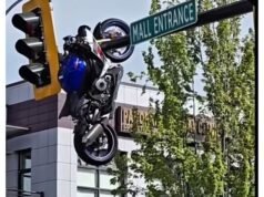 ¿Qué carajo? Moto queda colgada del semáforo tras accidente
