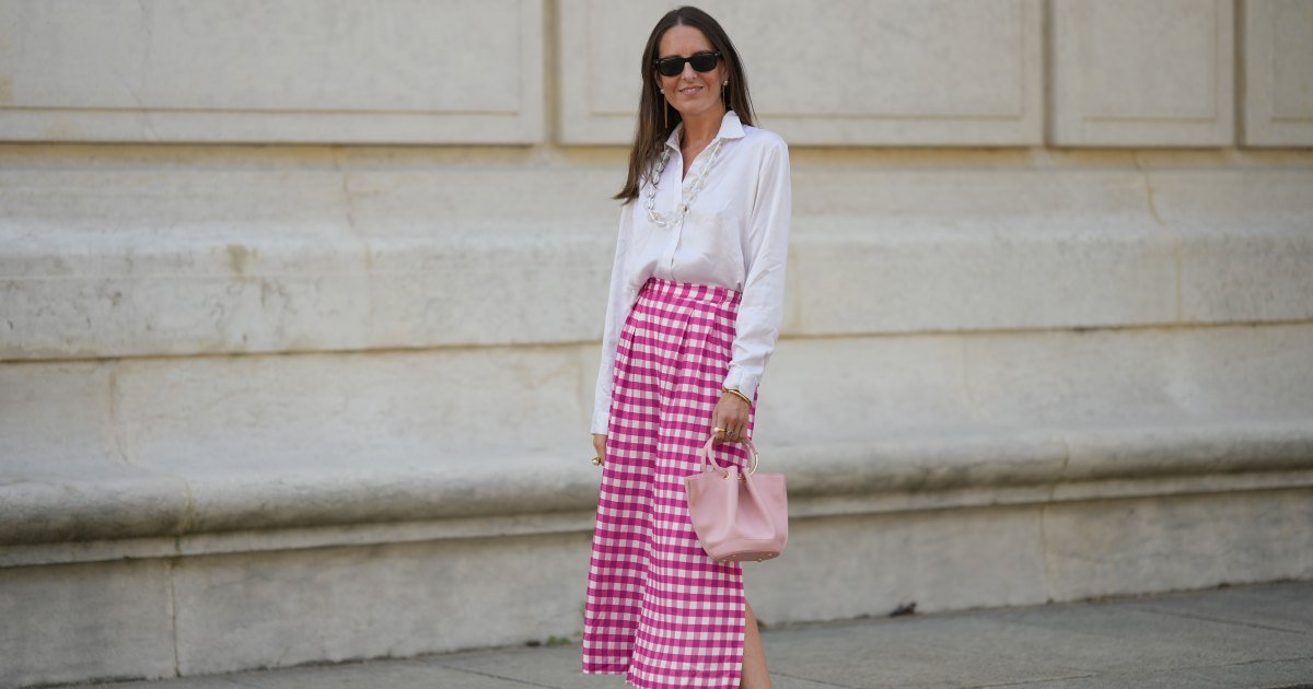 Alba Garavito Torre usa gafas de sol negras de Ray Ban, aretes colgantes de perlas blancas y cadena dorada, collar largo transparente con perlas grandes, camisa blanca, pantalones midi con estampado de cuadros rosas y blancos de Frambuã, pulseras doradas, bolso de cuero rosa pálido mate de Saonara Brand, mules de tacón en bloque de cuero blanco mate brillante con leche de Jonak, durante una sesión de fotos de moda de estilo callejero el 6 de junio de 2023 en París, Francia.